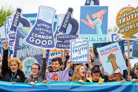 People with banners supporting science in the USA March for Science e.g. 'We have the solution', 'Scientists speaking truth to power'