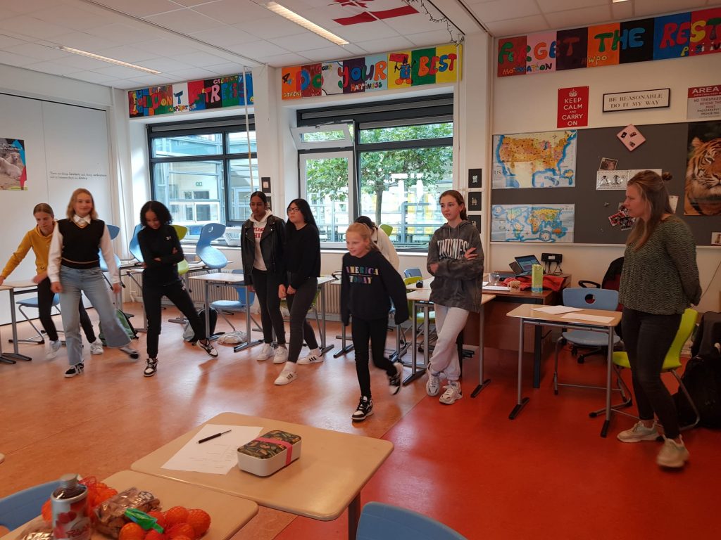 Teenagers in the Netherlands running across a classroom
