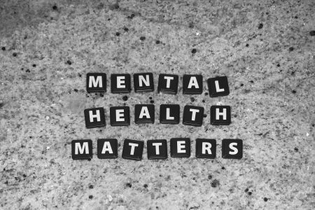 A grey marble surface with black tiles and white words. The words state 'Mental Health Matters'.