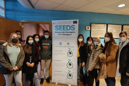 Teenage scientists and the SEEDS team standing beside a banner