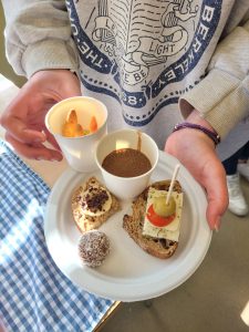 A teenager holding a plate with a variety of healthy snacks on it